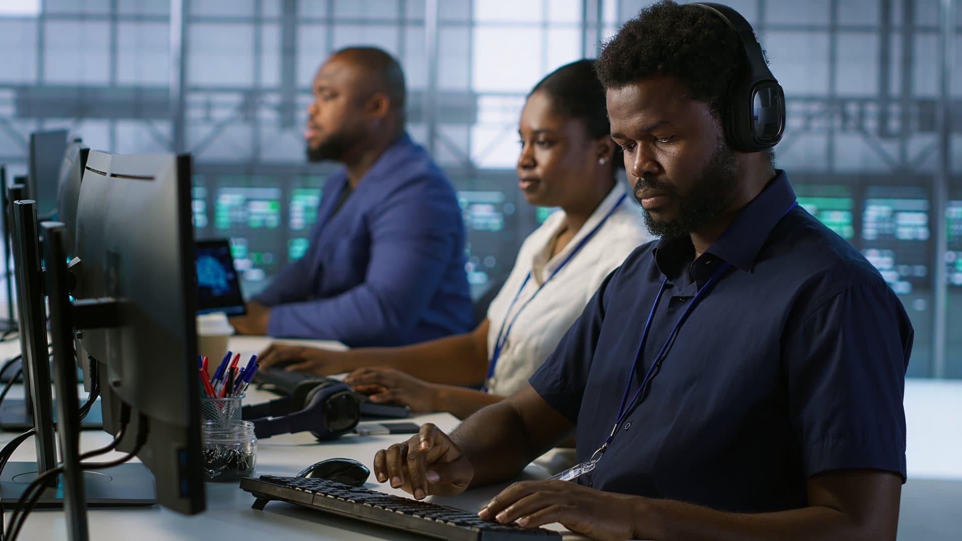 Operators coordinating from workstations in an institutional control room